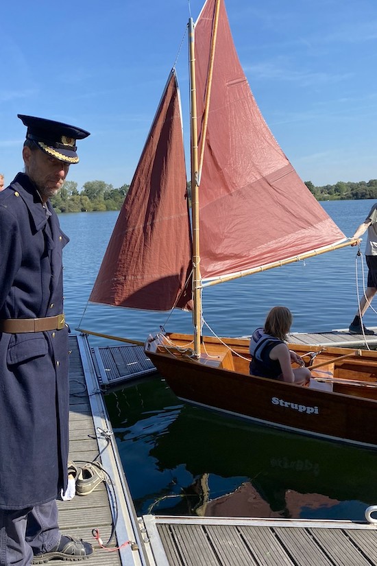 Gunnar vom YCM, verkleidet als Zöllner, vor den Segelbooten am Steg